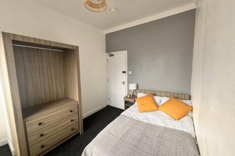 A neat double bedroom featuring a comfortable b...