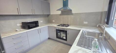 Modern kitchen with sleek grey units and marble...