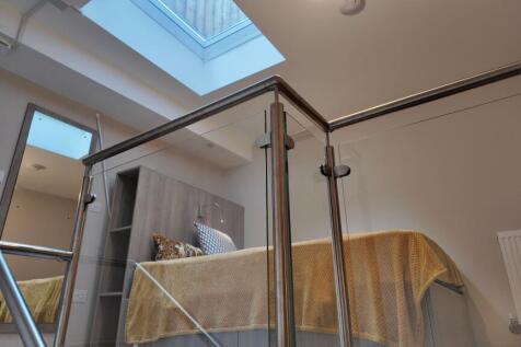 Contemporary bedroom with a raised bed dressed ...