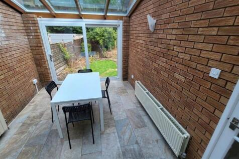 Bright brick-walled conservatory with a glass r...