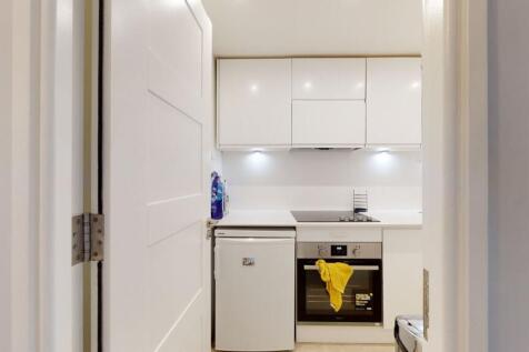 Bright, modern kitchenette with white gloss cab...