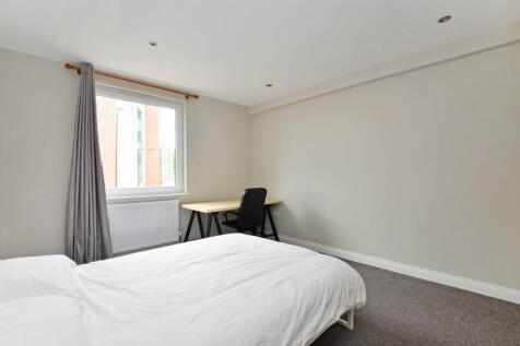 A bright and tidy bedroom featuring a comfortab...