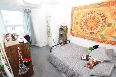 Bright bedroom with large window and wall decor...