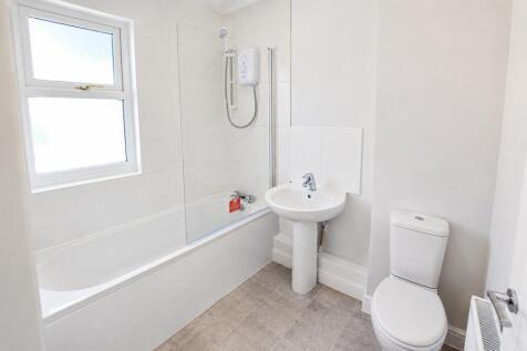 Modern white bathroom suite with bath and showe...