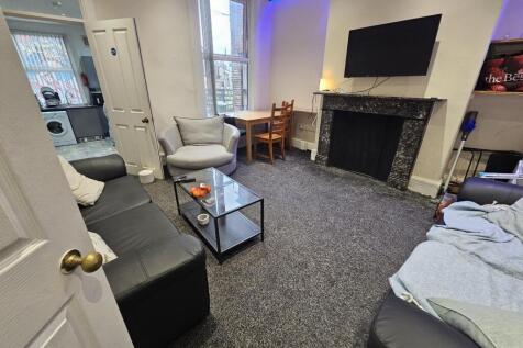 A modern, well-lit living room featuring a larg...