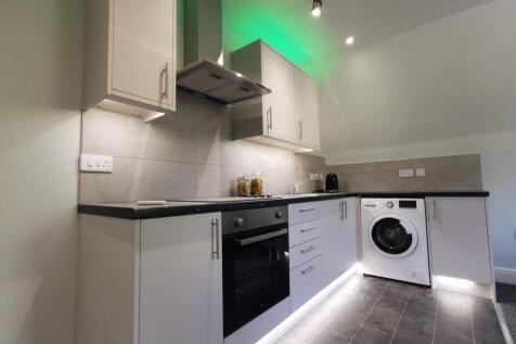 Modern kitchen with sleek units and LED lightin...