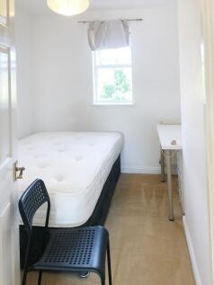 Bright, simply furnished bedroom with a double ...