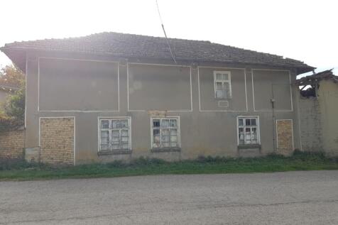 Exterior view of the two-storey house showing the front facade with three windows and a tiled roof