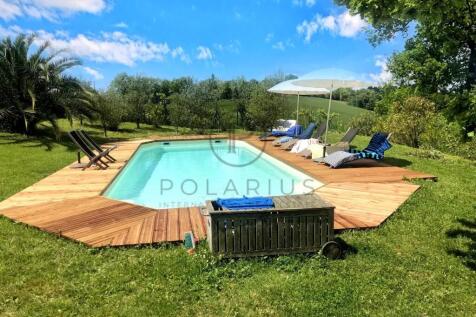 A serene outdoor pool with a wooden deck, surround