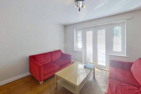 Bright, tidy living room with matching red sofa...