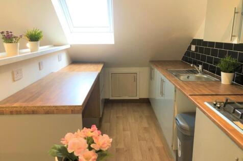 Bright and modern kitchen featuring ample woode...