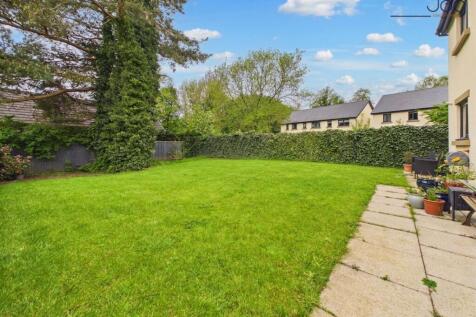 West facing Garden with a mixture of lawn and flags for a seating area.