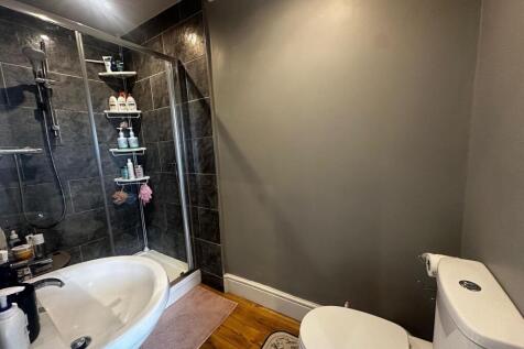 Modern bathroom with a walk-in shower, white ba...