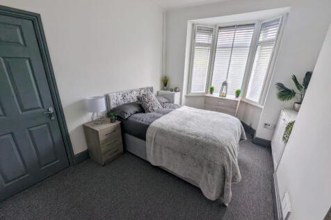 Bright, neatly styled bedroom with a comfortabl...