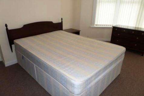 Bright, simply furnished bedroom with a double ...