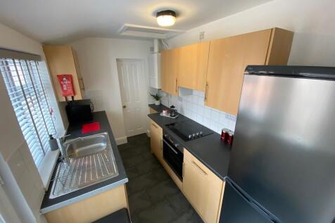 Bright, modern galley kitchen with light wood c...