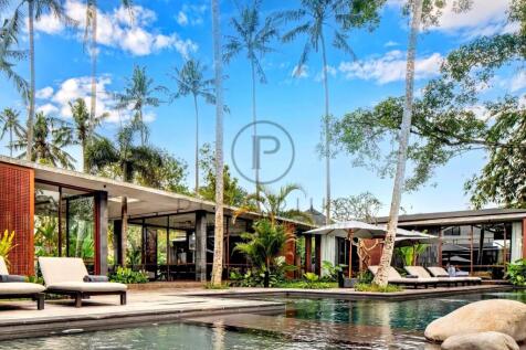 A modern tropical villa with large glass windows i