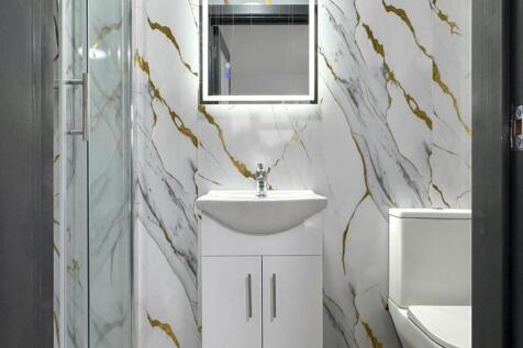 Contemporary bathroom with marble-effect wall t...