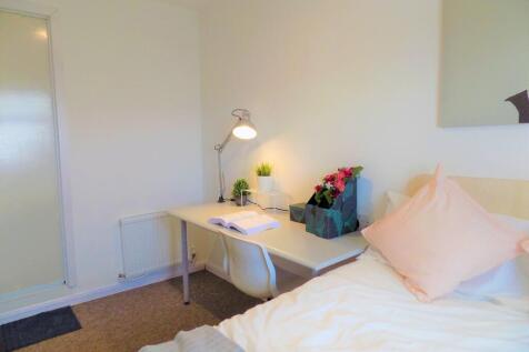 A neat and cozy single bedroom featuring a comp...