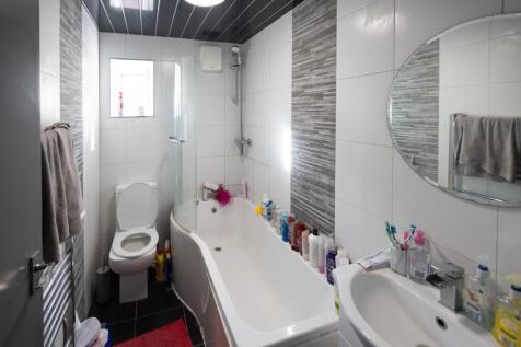 A modern bathroom suite featuring a curved bath...
