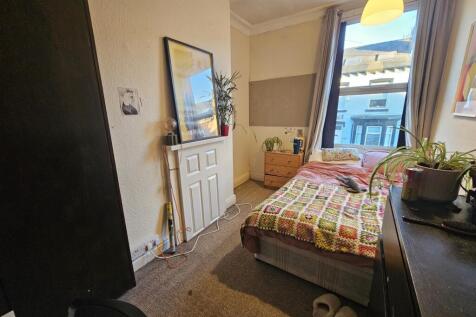 Bright, neatly arranged bedroom with a comforta...