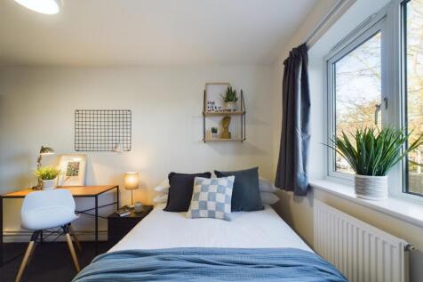 A bright and inviting double bedroom with a coz...
