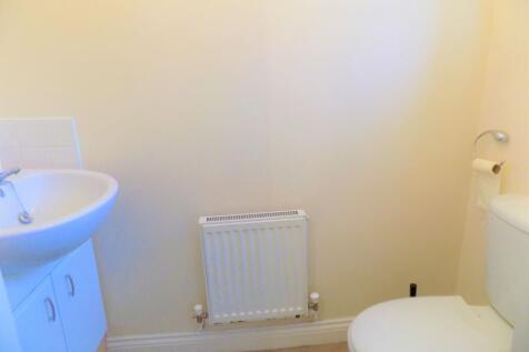 A clean and simple toilet room featuring a whit...