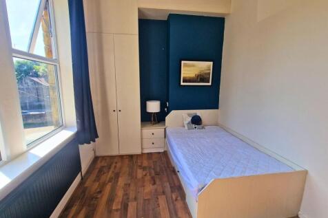 Bright single bedroom with a large sash window,...