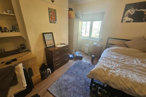 A spacious and well-lit master bedroom featurin...