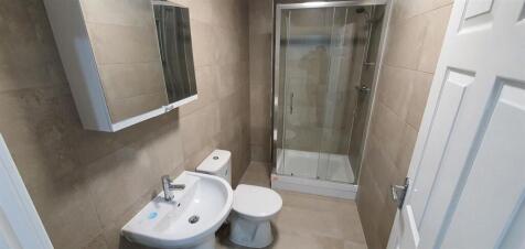 Modern tiled bathroom with a combined shower-ba...