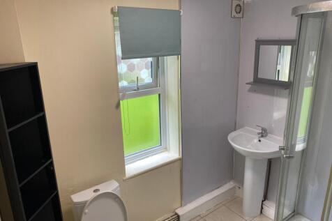 A practical bathroom featuring a small sink, to...