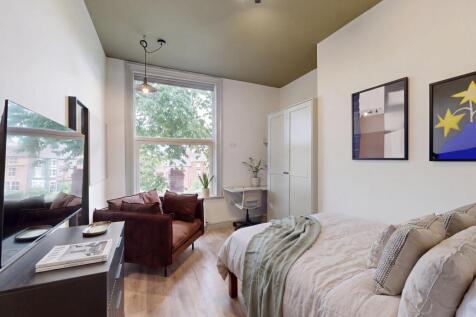 Stylish bedroom with study desk and cozy seatin...