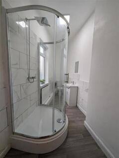 Modern bathroom with a curved glass shower encl...