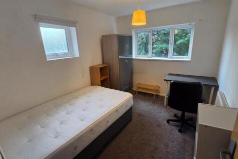 Bright, simply furnished bedroom with a mattres...