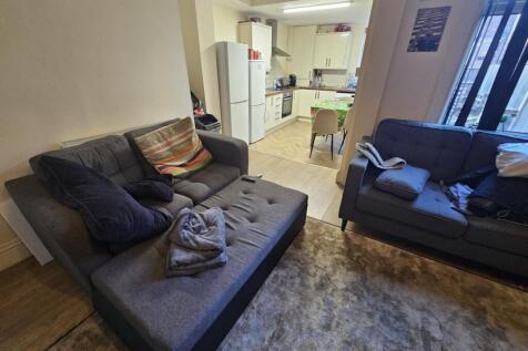 Comfortable open-plan living area with two sofa...