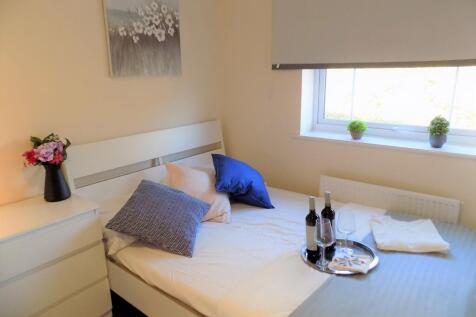 Bright, neatly presented bedroom with a white b...