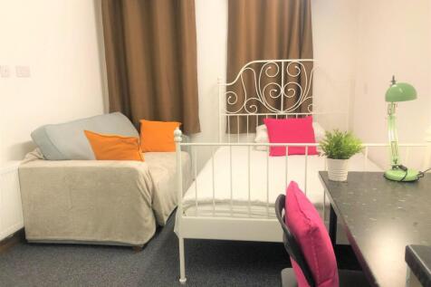 A cozy single bedroom featuring a white ornate ...