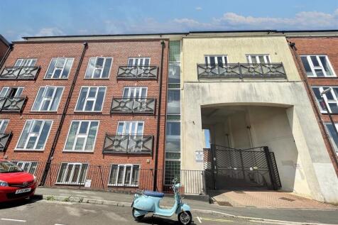 Modern apartment exterior under a clear blue sk...