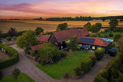 Aerial drone view of The Tithe Barn at sunset, dar