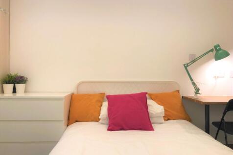 A cozy and tidy single bedroom featuring a comf...
