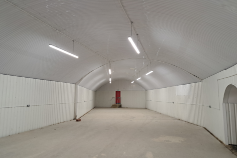 An empty arch with white lining and a fire escape door at the back.