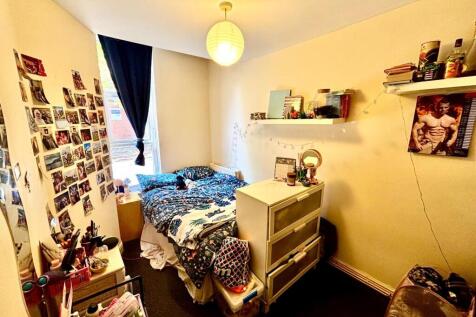 Cozy bedroom featuring a bed with vibrant beddi...