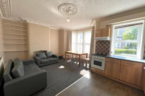 Bright open-plan living area with bay windows, ...