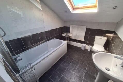 Bright and modern bathroom featuring a bathtub,...