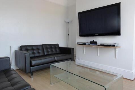 Modern living room featuring a sleek black leat...