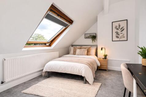 Bright attic bedroom with large skylight window...