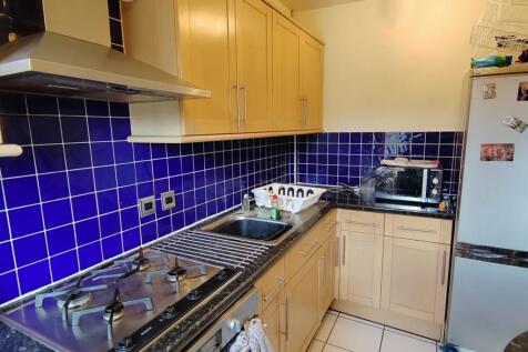 Bright kitchen with vibrant blue tile backsplas...