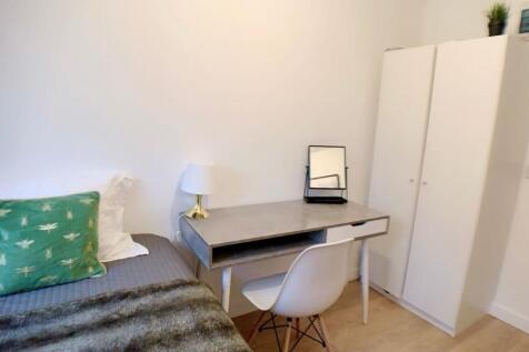 A cozy bedroom featuring a bed with decorative ...