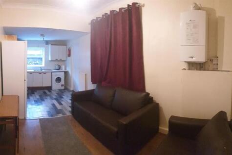 Compact open-plan living area with two black so...