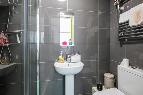 Modern tiled bathroom with a pedestal sink, gla...
